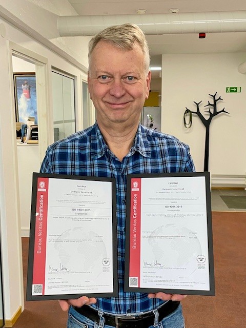 Man holding two certificates in his hands